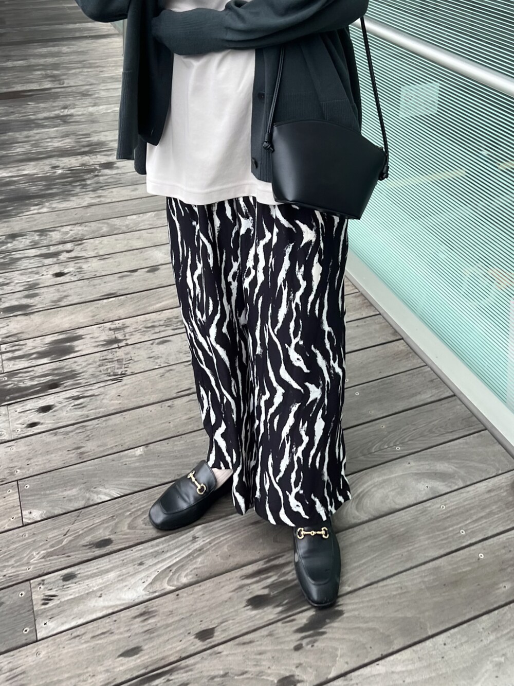 ブラック系のその他パンツ、グレー系のカーディガン/ボレロ、ブラック系のバッグを着用したレディースの春コーディネートの2枚目の写真