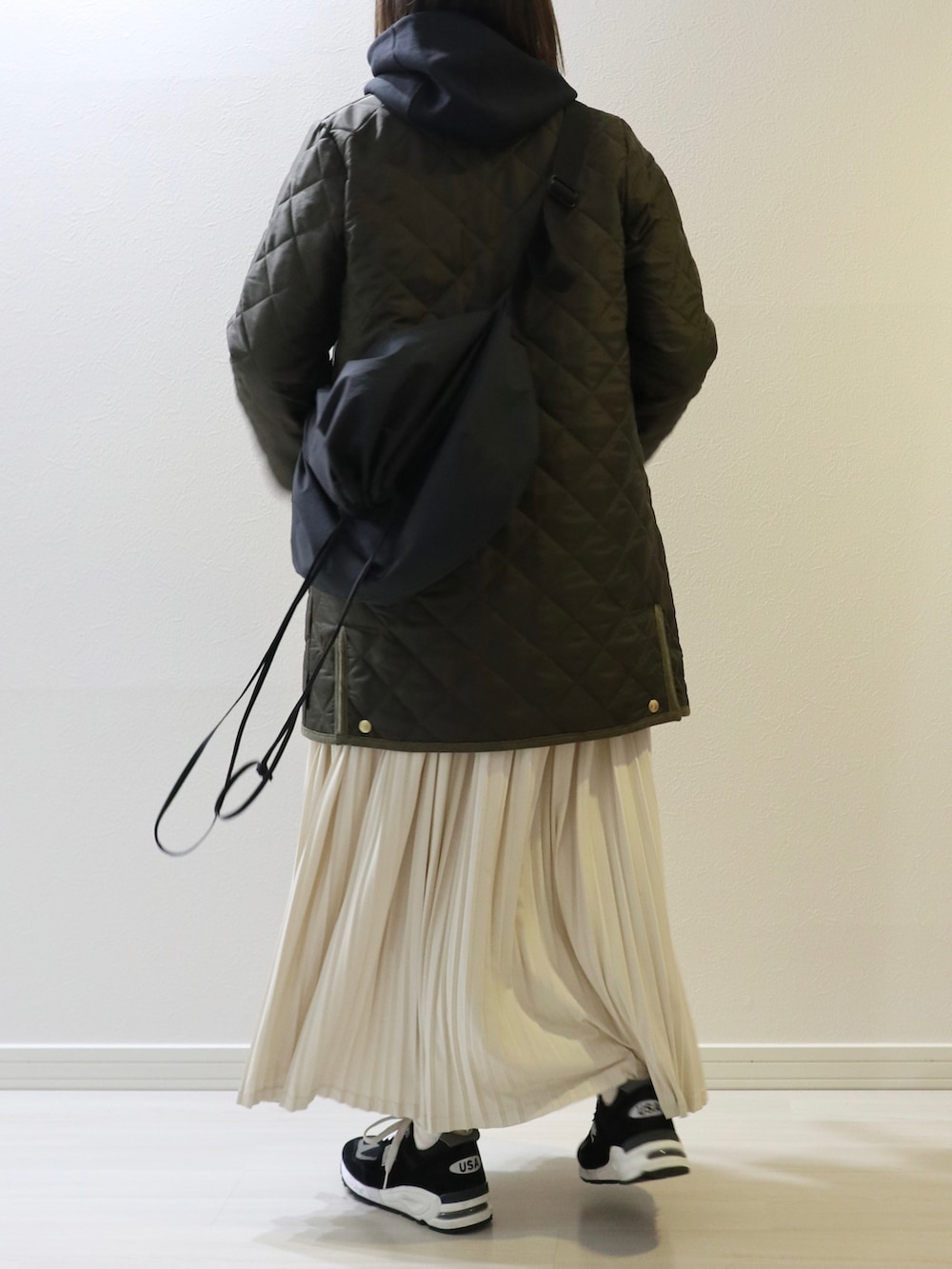 グリーン系のその他アウター、ホワイト系のスカート、オレンジ系のニット/セーターを着用したレディースの秋コーディネートの3枚目の写真