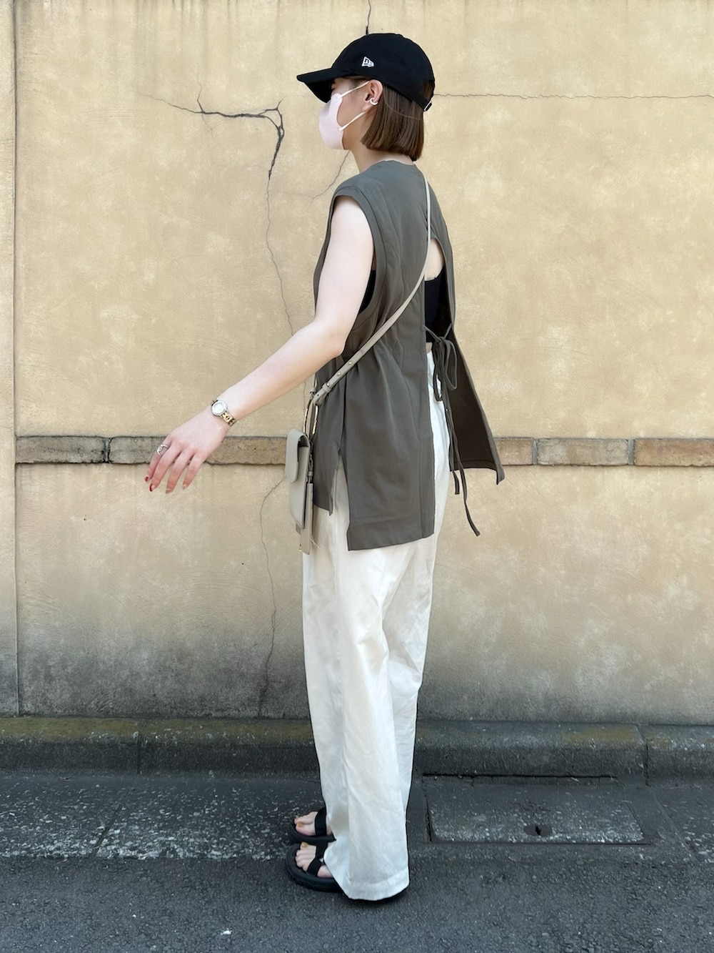 グリーン系のTシャツ/カットソー、ベージュ系のショルダーバッグ、ホワイト系のパンツを着用したレディースの夏コーディネートの3枚目の写真