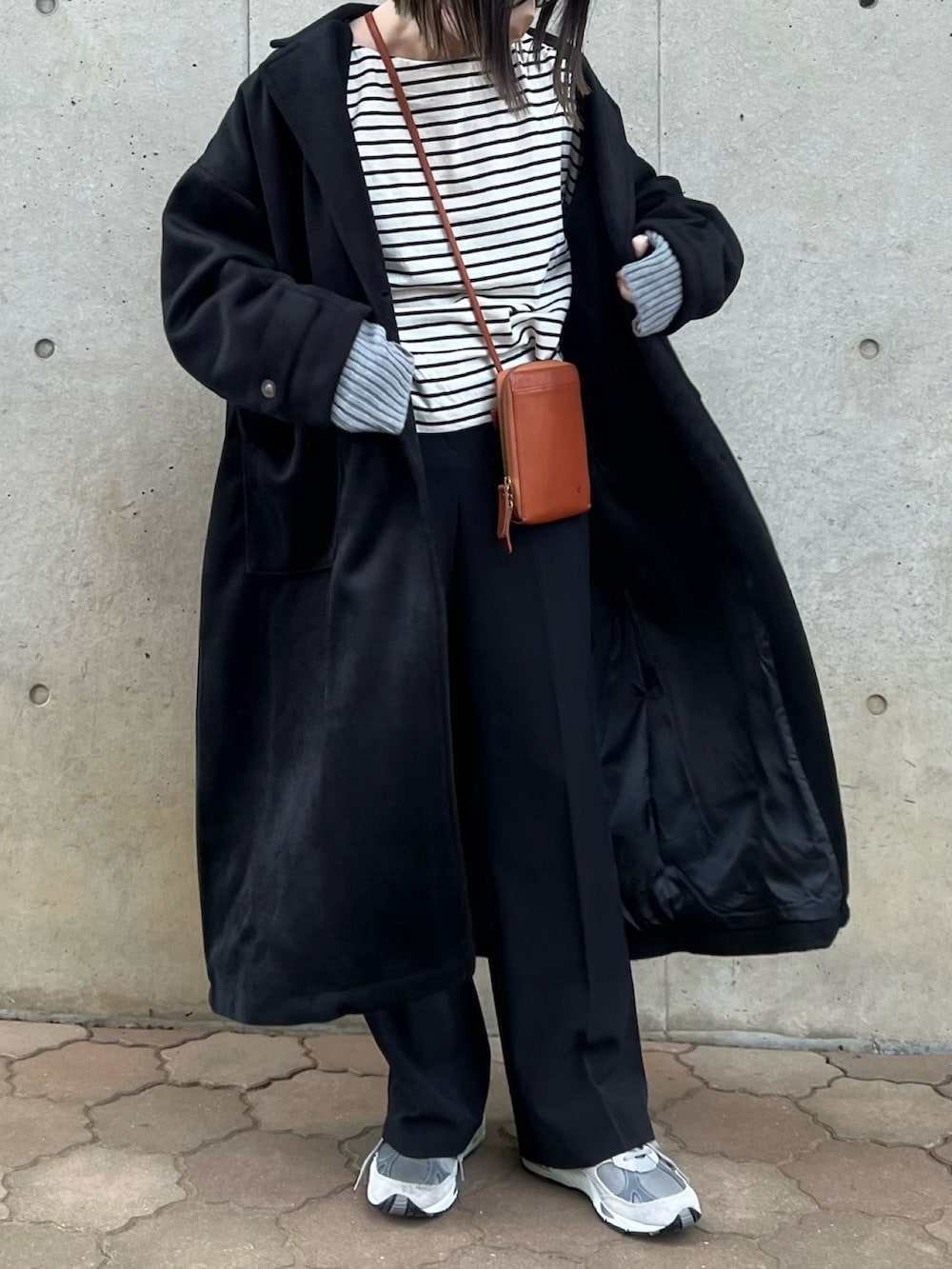 ブラック系のダウンジャケット/コート、ホワイト系のTシャツ/カットソー、イエロー系のショルダーバッグを着用したレディースの秋コーディネートの2枚目の写真