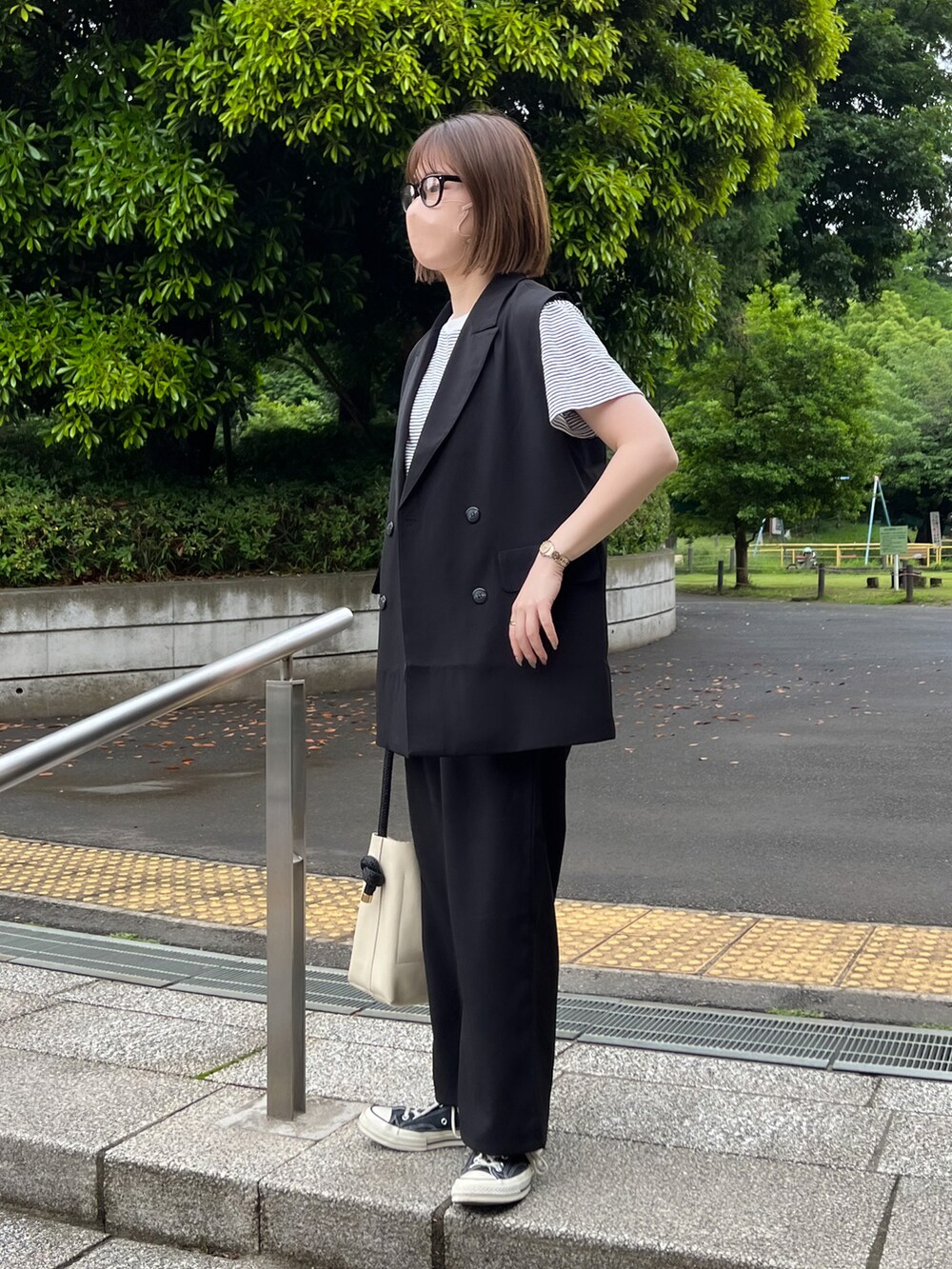 ブラック系のベスト、ブラック系のその他パンツ、ホワイト系のTシャツ/カットソーを着用したレディースの春コーディネートの2枚目の写真