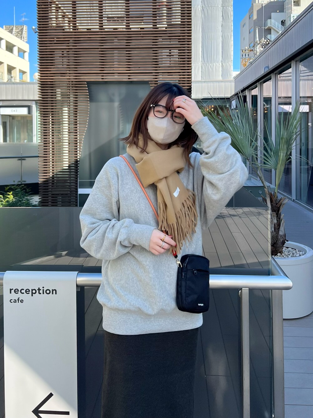 ブラック系のスカート、グレー系のスウェット、ブラック系のバッグを着用したレディースの冬コーディネートの3枚目の写真