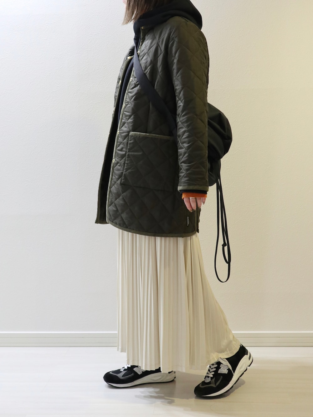 グリーン系のその他アウター、ホワイト系のスカート、オレンジ系のニット/セーターを着用したレディースの秋コーディネートの2枚目の写真