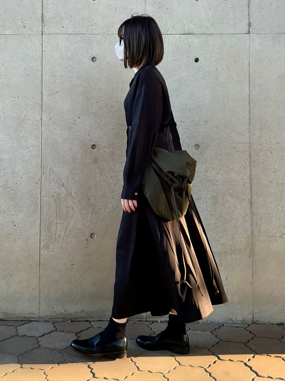 ブラック系のワンピース、グリーン系のショルダーバッグ、ブラック系のシューズを着用したレディースの秋コーディネートの3枚目の写真