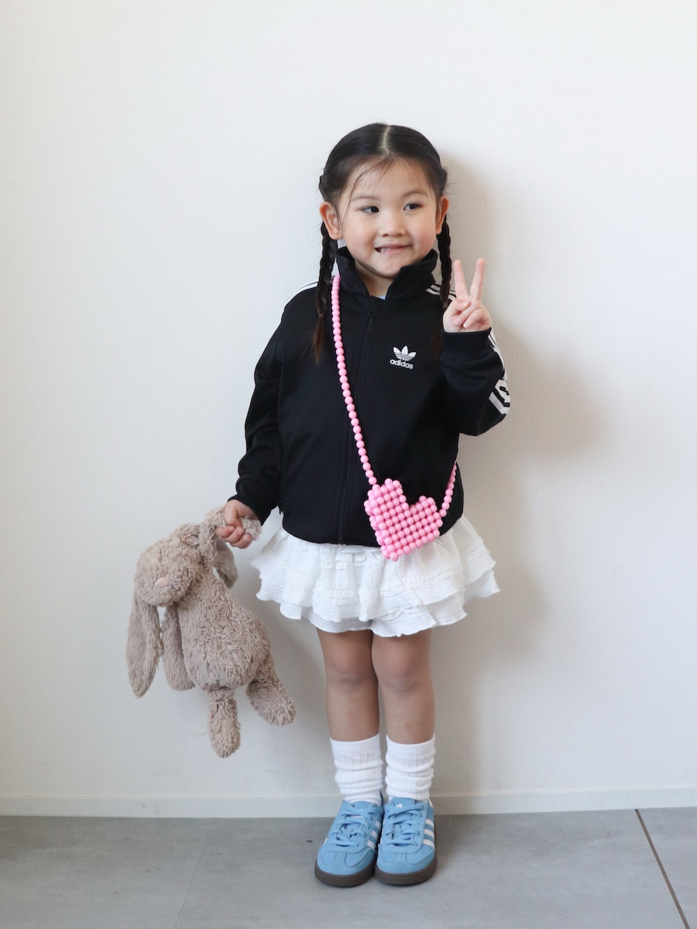 ホワイト系のその他パンツ、ブルー系のスニーカー、レッド系のショルダーバッグを着用したキッズの春コーディネートの2枚目の写真