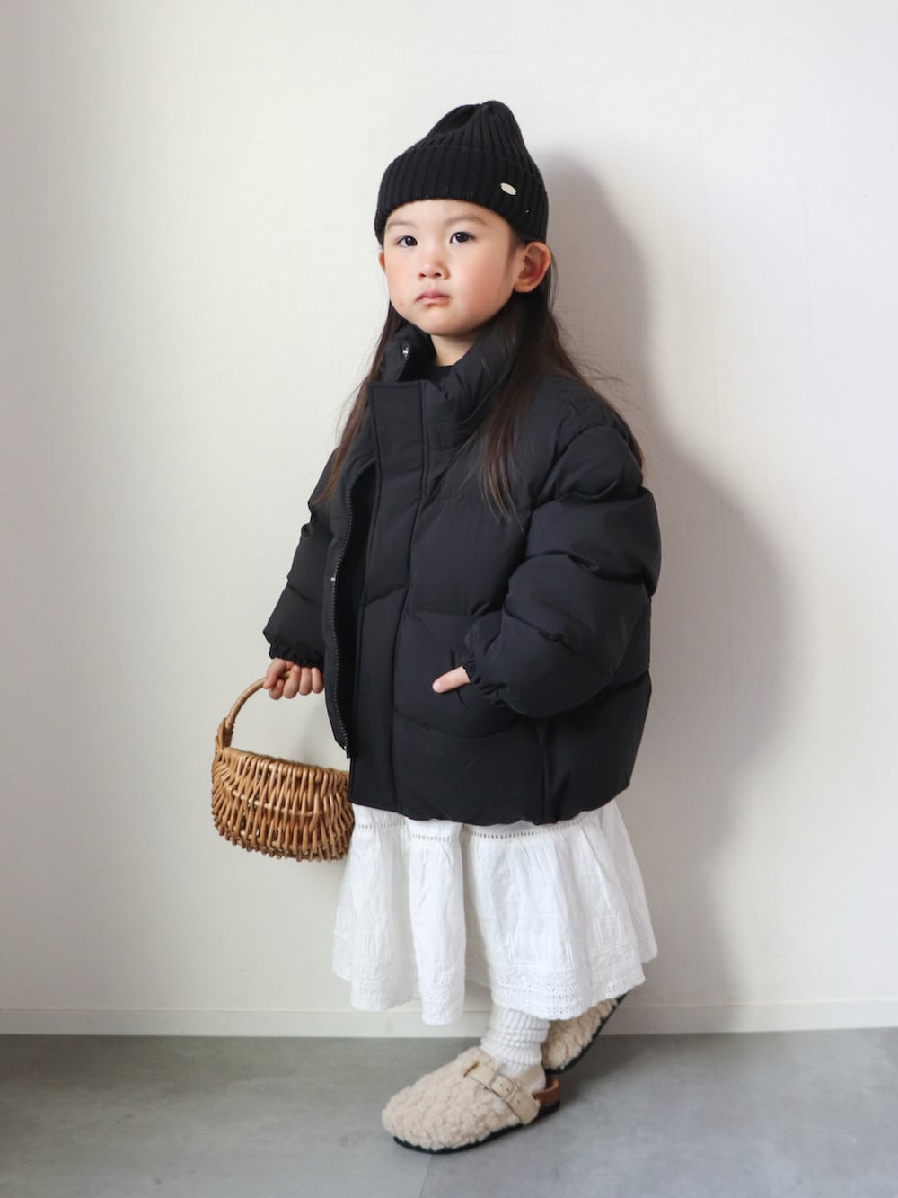 ブラウン系のTシャツ/カットソー、ホワイト系のスカート、ホワイト系のサンダルを着用したキッズの冬コーディネートの2枚目の写真