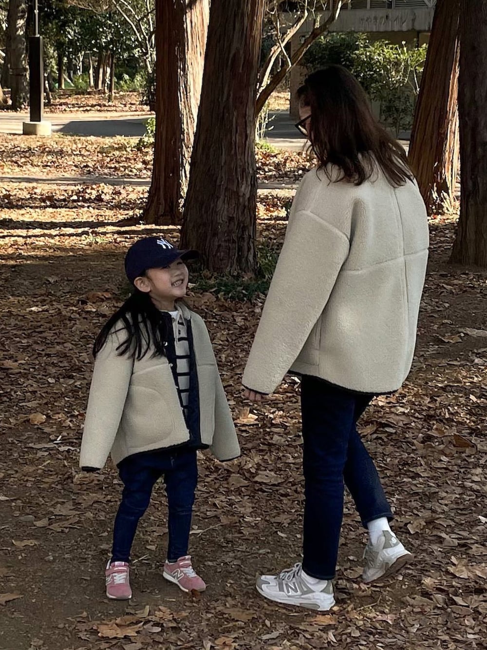 ホワイト系のブルゾン、ホワイト系のニット/セーター、ベージュ系のスニーカーを着用したキッズの冬コーディネートの2枚目の写真