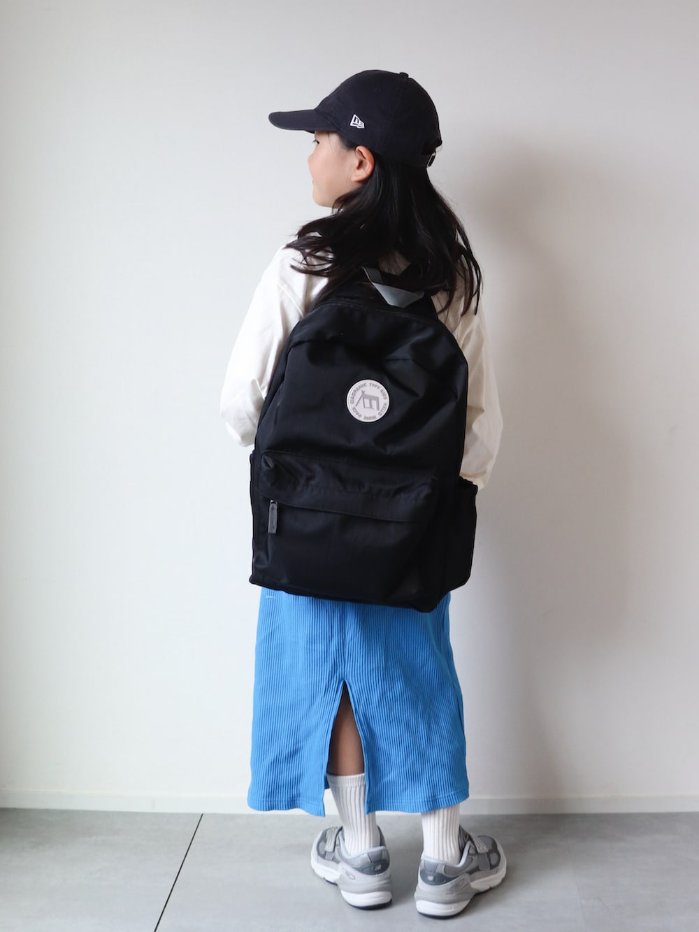 ホワイト系のTシャツ/カットソー、ブルー系のスカート、グレー系のスニーカーを着用したキッズの夏コーディネートの2枚目の写真