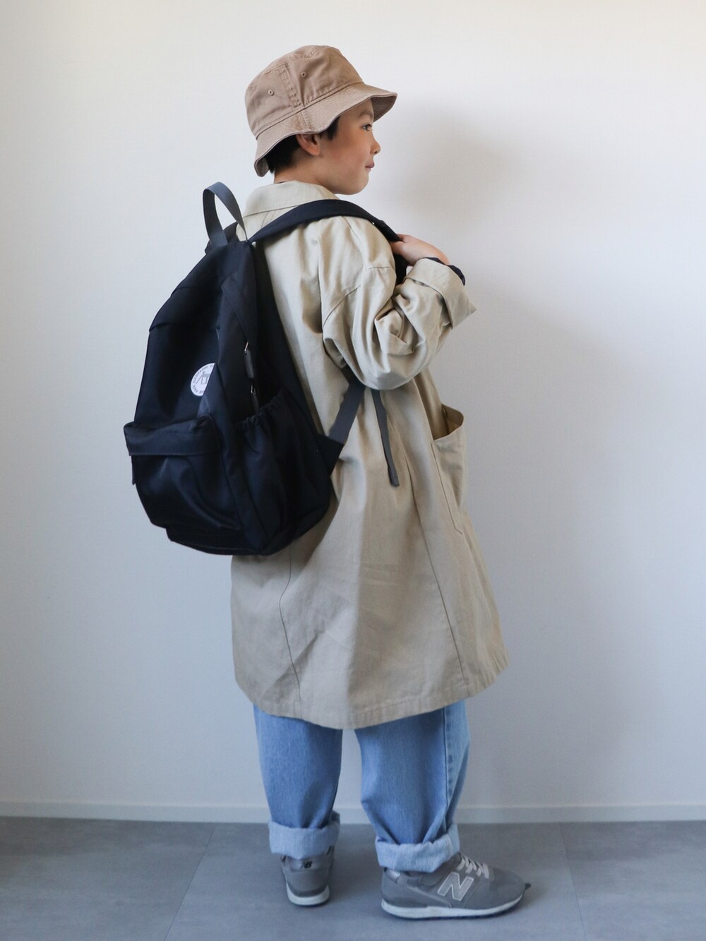 ベージュ系のトレンチコート、ブルー系のシャツ/ブラウス、ブルー系のTシャツ/カットソーを着用したキッズの冬コーディネートの3枚目の写真