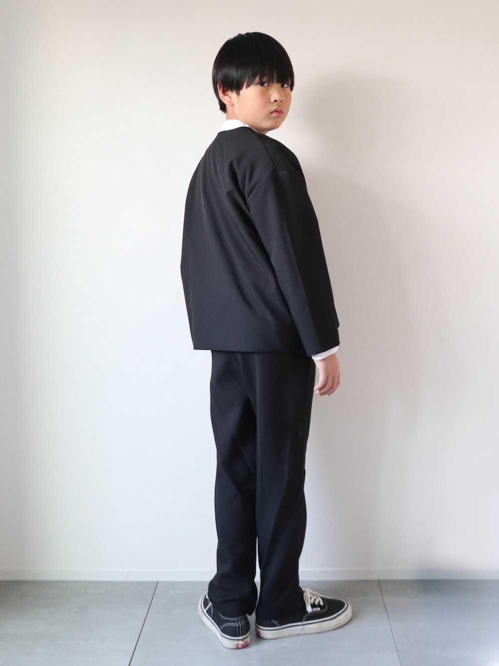 ブラック系のスーツセット、ホワイト系のシャツ/ブラウス、ブラック系のスニーカーを着用したキッズの冬コーディネートの4枚目の写真