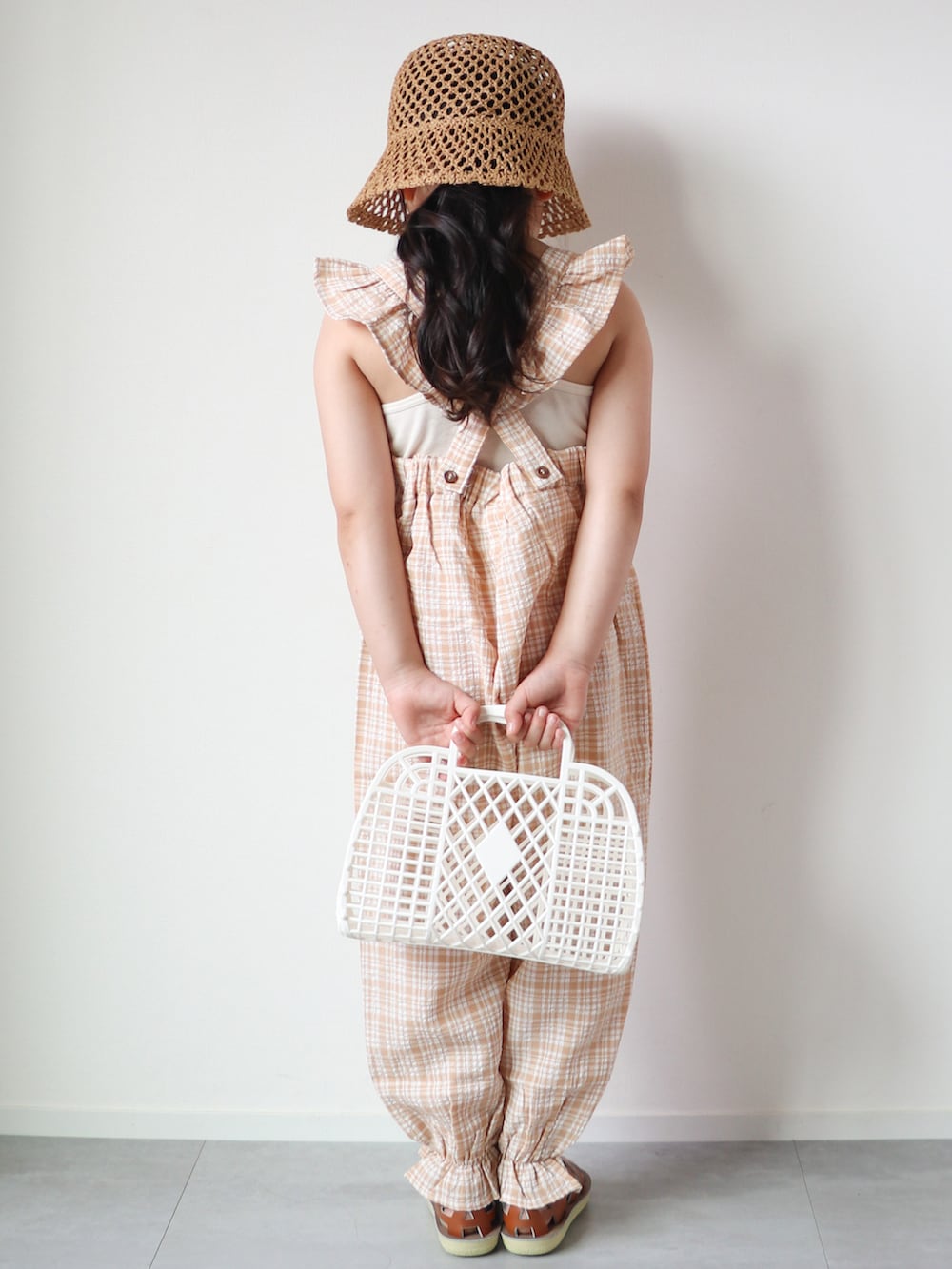 ベージュ系のサロペット/オーバーオール、ベージュ系のキャミソール、ブラウン系のサンダルを着用したキッズの春コーディネートの4枚目の写真