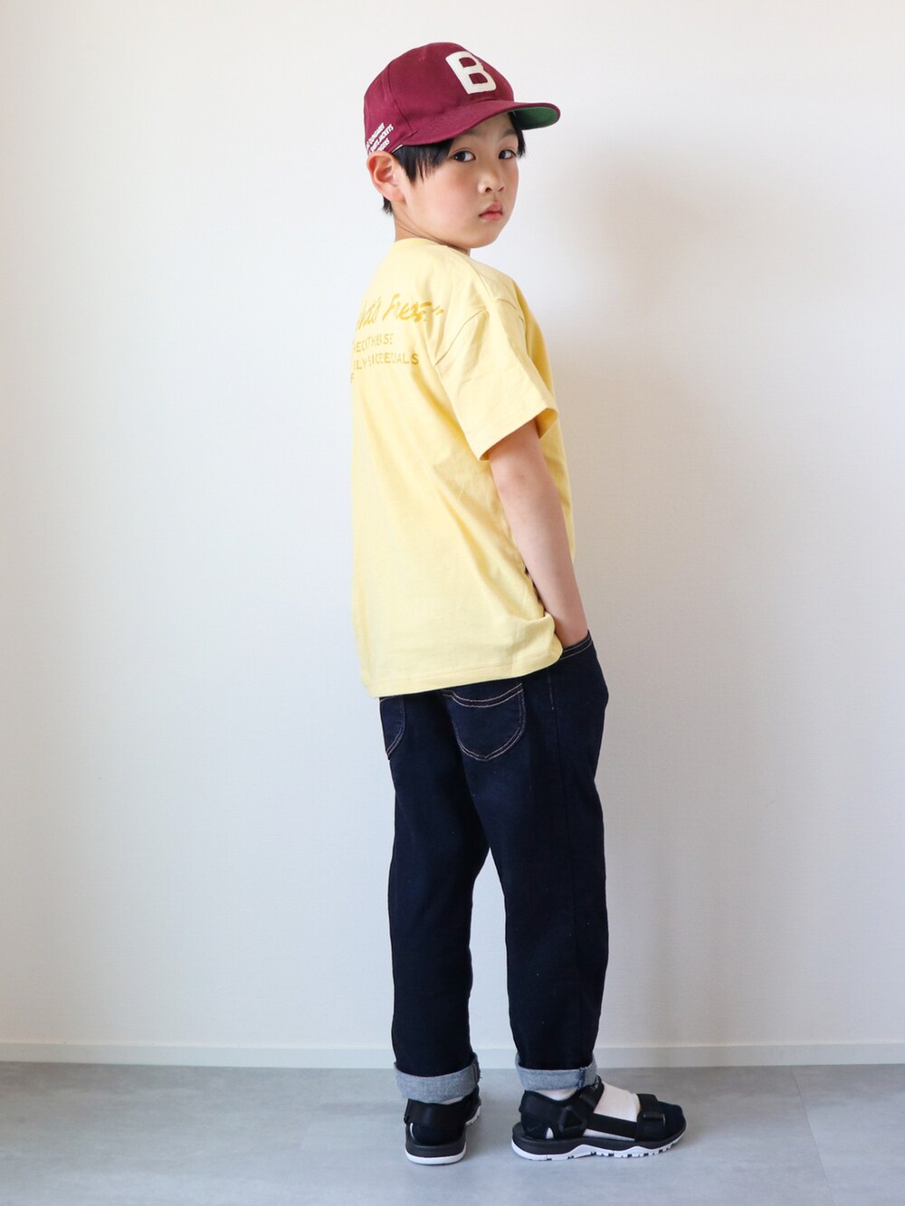 イエロー系のTシャツ/カットソー、ブルー系のデニムパンツ、ブラック系のサンダルを着用したキッズの夏コーディネートの2枚目の写真