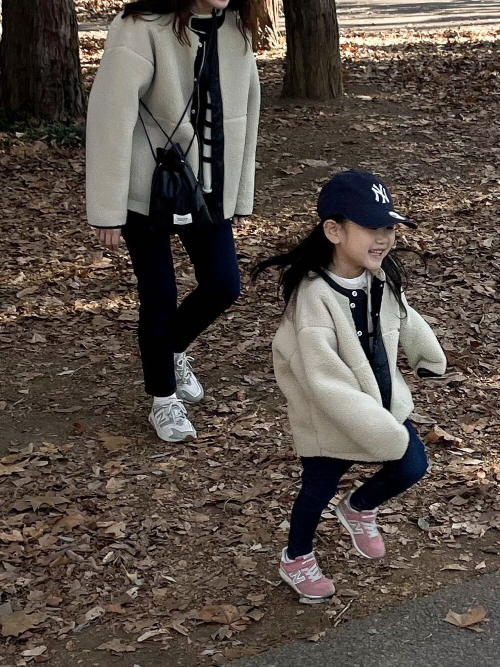 ホワイト系のブルゾン、ホワイト系のニット/セーター、ベージュ系のスニーカーを着用したキッズの冬コーディネートの3枚目の写真