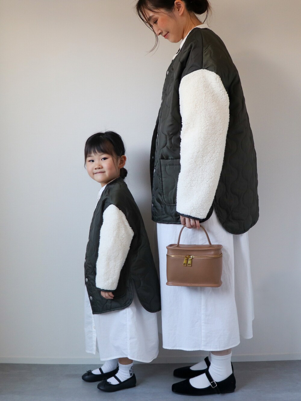 グリーン系のノーカラージャケット、ブラック系のワンピース、ブラック系のバレエシューズを着用したキッズの秋コーディネートの2枚目の写真