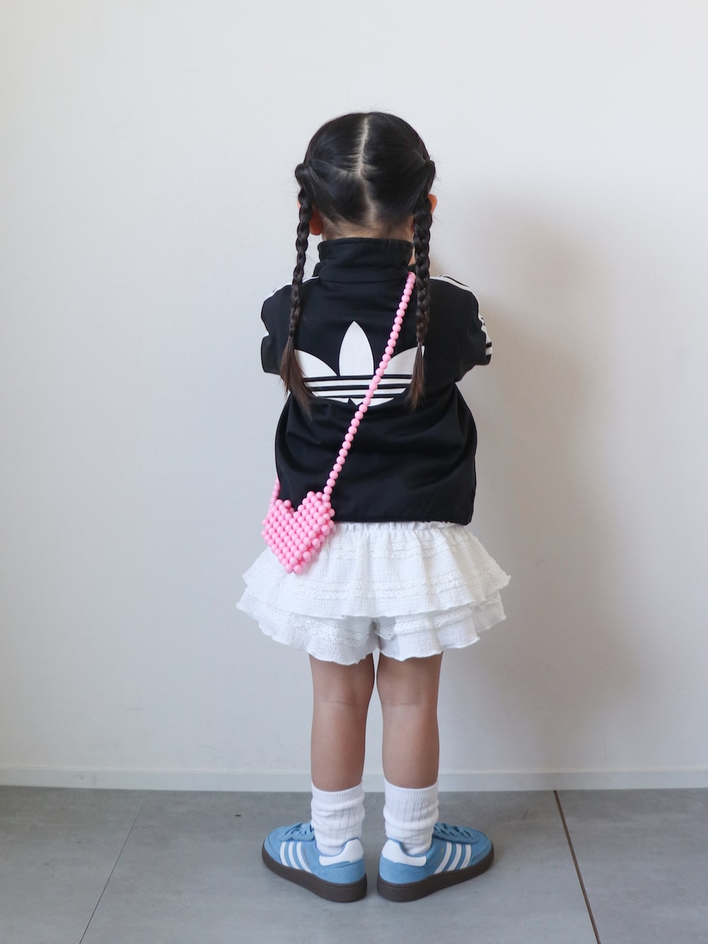 ホワイト系のその他パンツ、ブルー系のスニーカー、レッド系のショルダーバッグを着用したキッズの春コーディネートの3枚目の写真