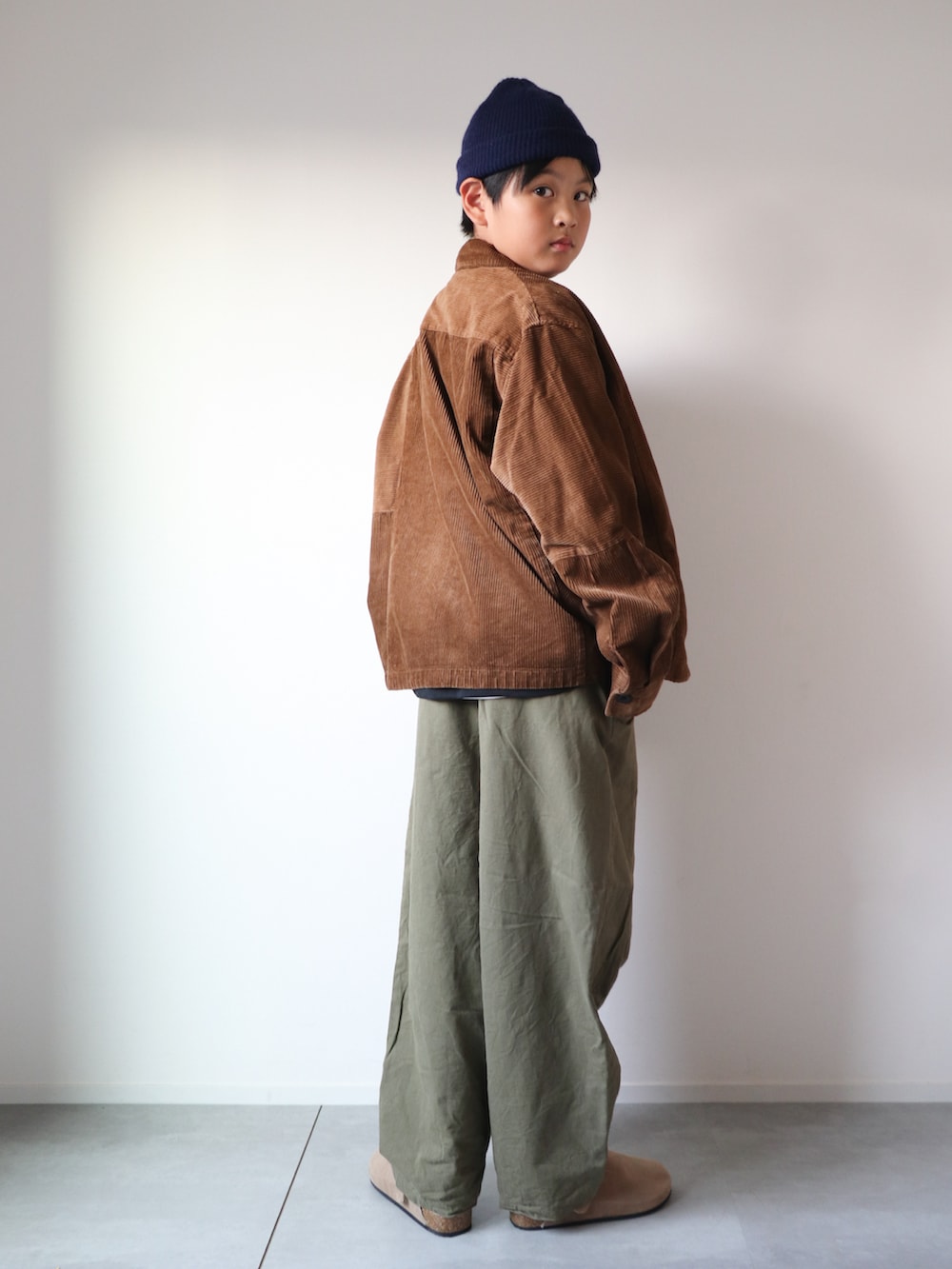 ブラック系のTシャツ/カットソー、グリーン系のカーゴパンツ、ベージュ系のスリッポンを着用したキッズの秋コーディネートの2枚目の写真