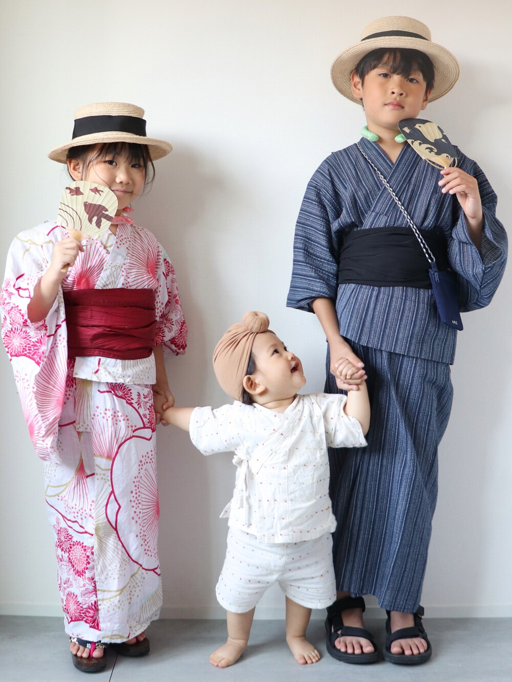 ブラック系のサンダル、ベージュ系のハット、ブルー系の浴衣を着用したキッズの夏コーディネートの3枚目の写真