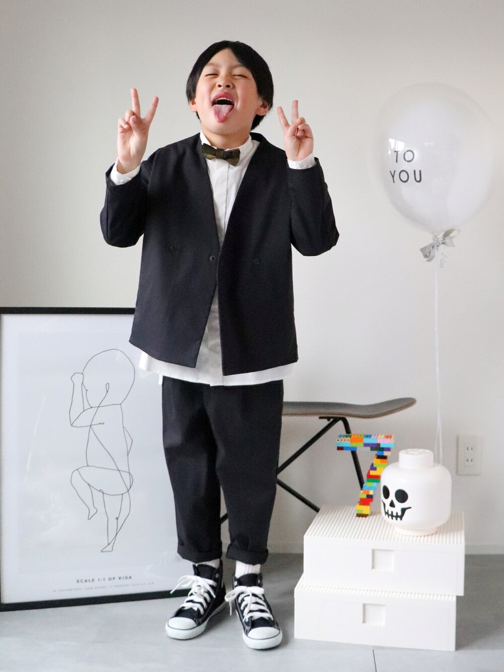 ブラック系のノーカラージャケット、ホワイト系のシャツ/ブラウス、ブラック系のその他パンツを着用したキッズの冬コーディネートの4枚目の写真