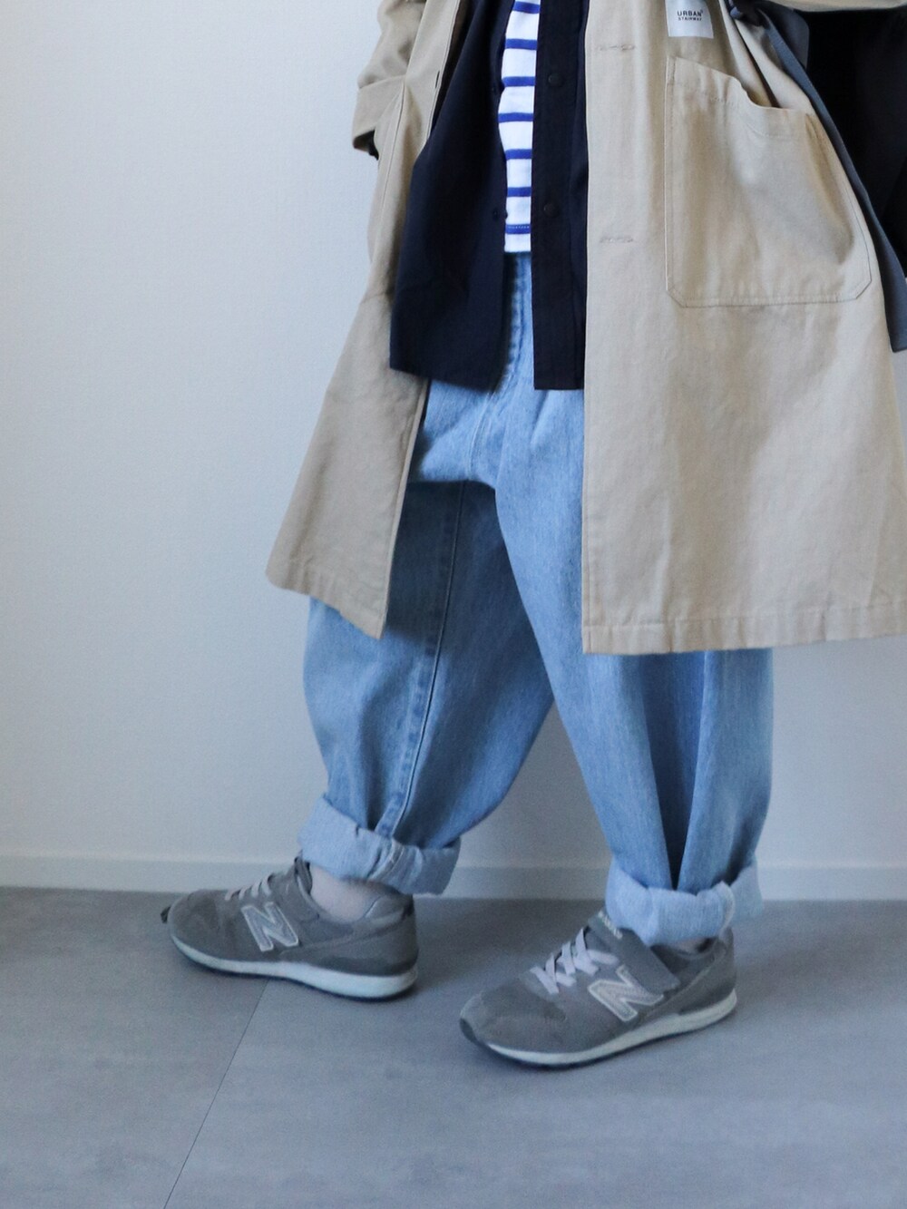 ベージュ系のトレンチコート、ブルー系のシャツ/ブラウス、ブルー系のTシャツ/カットソーを着用したキッズの冬コーディネートの4枚目の写真