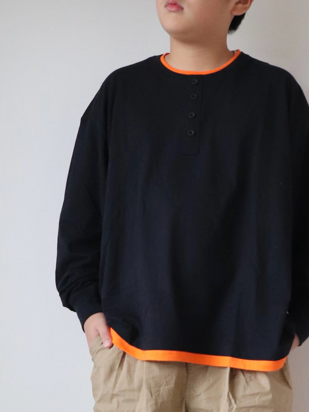 ブラック系のTシャツ/カットソー、ベージュ系のその他パンツ、グレー系のスニーカーを着用したキッズの秋コーディネートの2枚目の写真