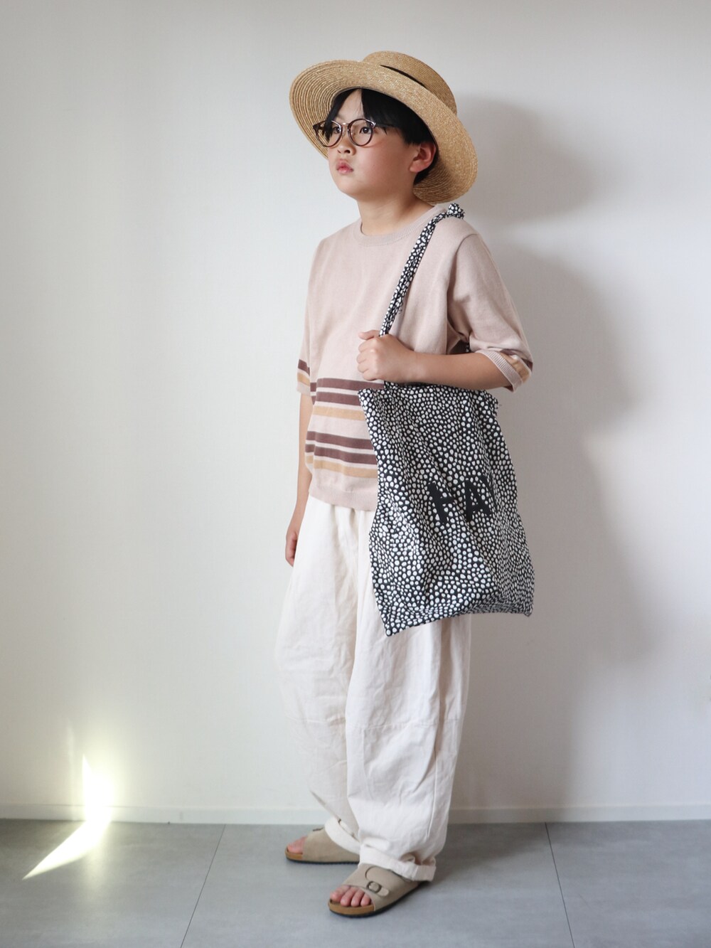 ベージュ系のニット/セーター、ホワイト系のその他パンツ、ベージュ系のサンダルを着用したキッズの春コーディネートの4枚目の写真