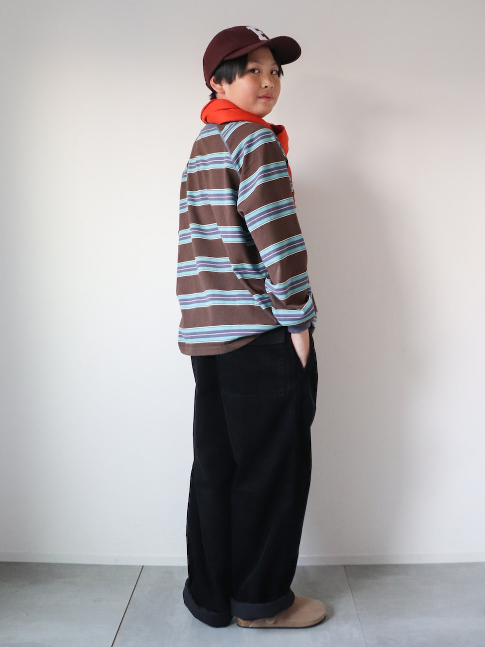 ブラウン系のTシャツ/カットソー、ブラック系のパンツ、ベージュ系のスリッポンを着用したキッズの冬コーディネートの3枚目の写真