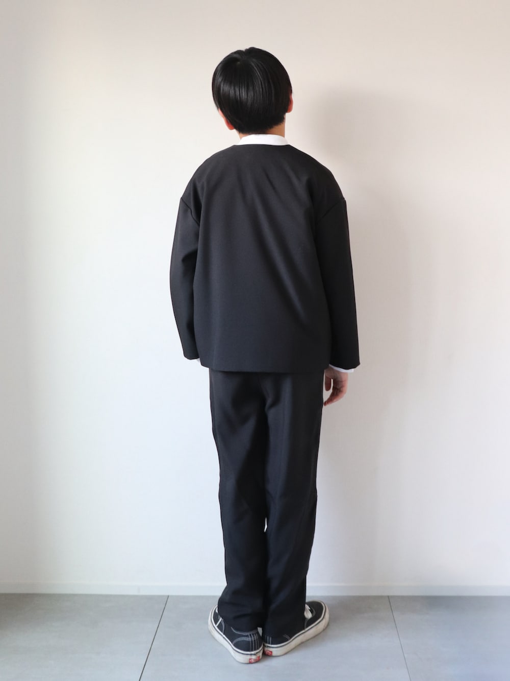 ブラック系のスーツセット、ホワイト系のシャツ/ブラウス、ブラック系のスニーカーを着用したキッズの冬コーディネートの3枚目の写真