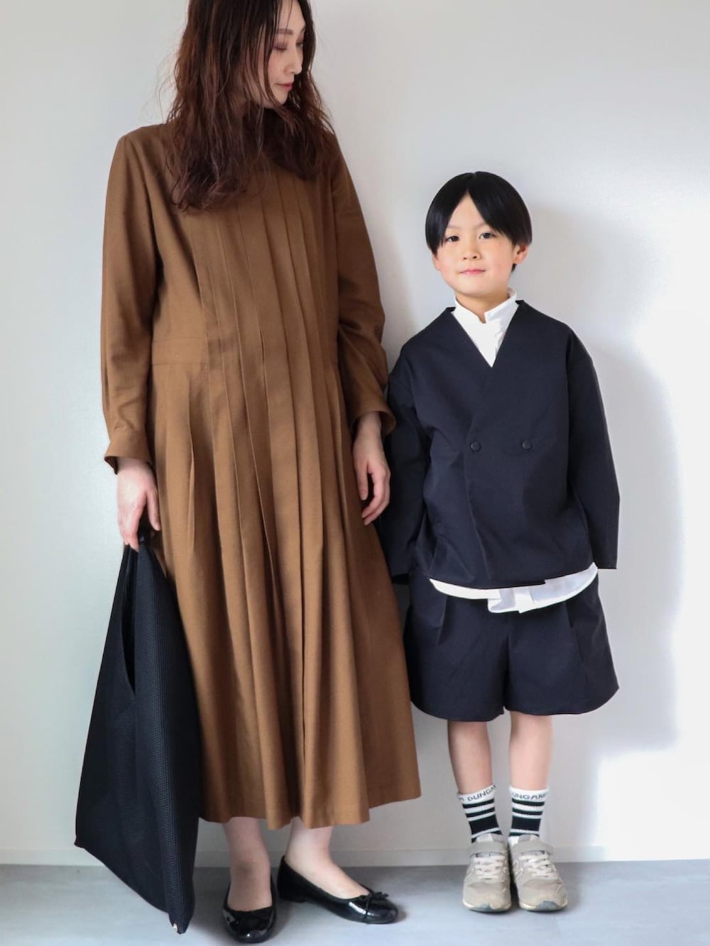 ブラック系のその他アウター、ホワイト系のシャツ/ブラウス、ブラック系のパンツを着用したキッズの春コーディネートの2枚目の写真