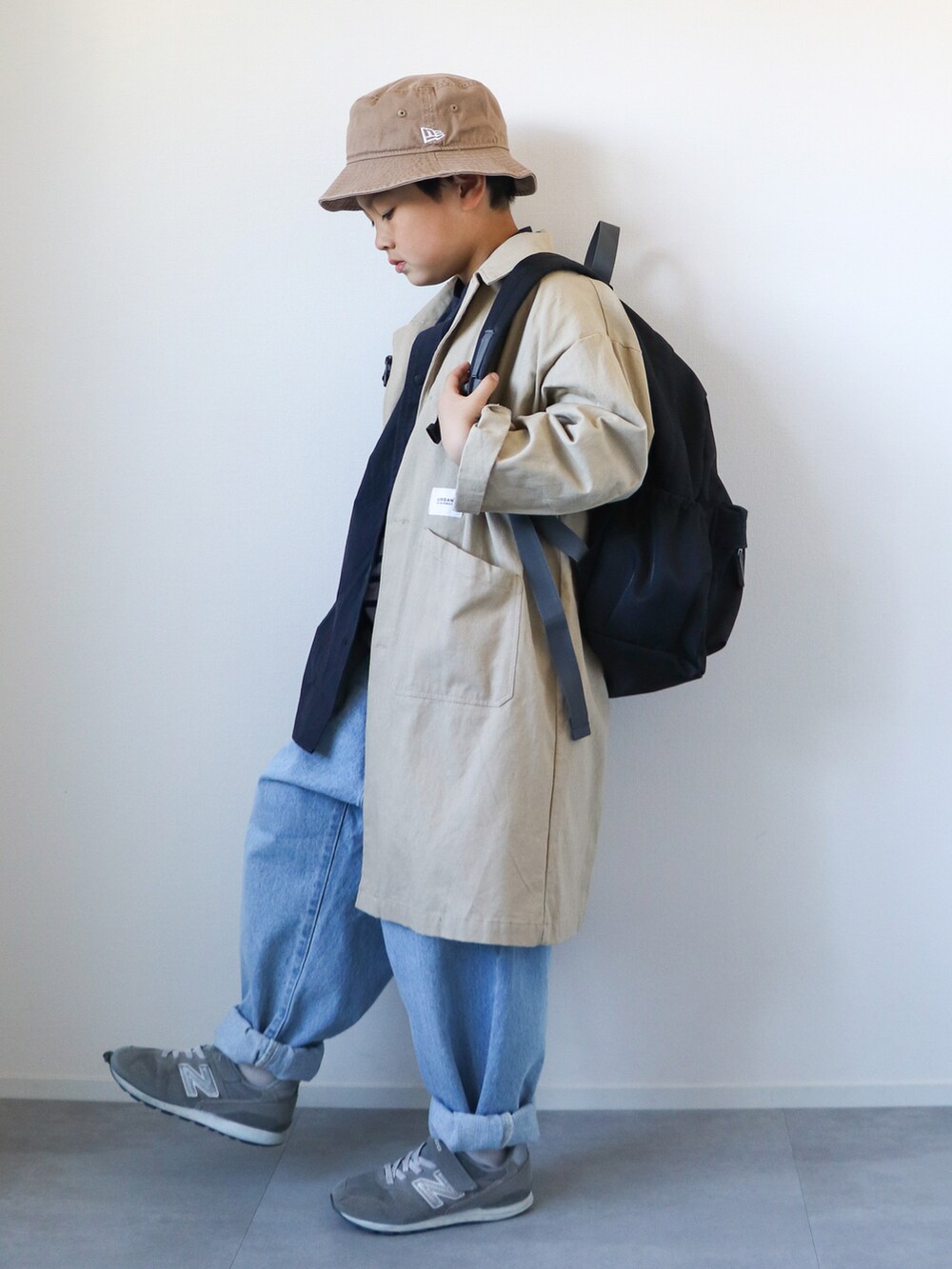 ベージュ系のトレンチコート、ブルー系のシャツ/ブラウス、ブルー系のTシャツ/カットソーを着用したキッズの冬コーディネートの2枚目の写真