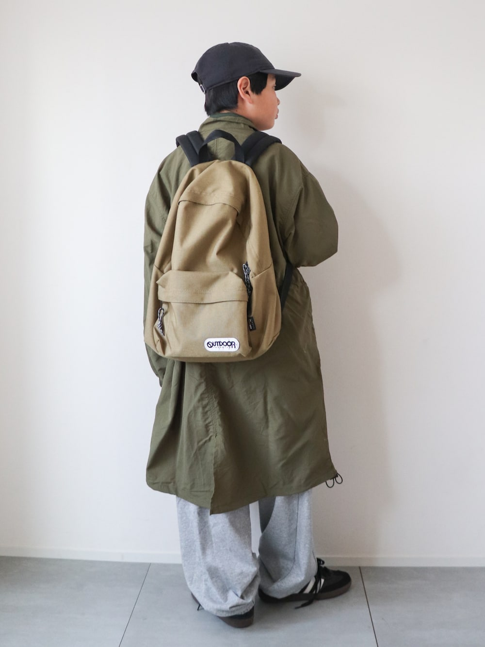 グリーン系のテーラードジャケット、グリーン系のポロシャツ、グレー系のスウェットパンツを着用したキッズの冬コーディネートの4枚目の写真