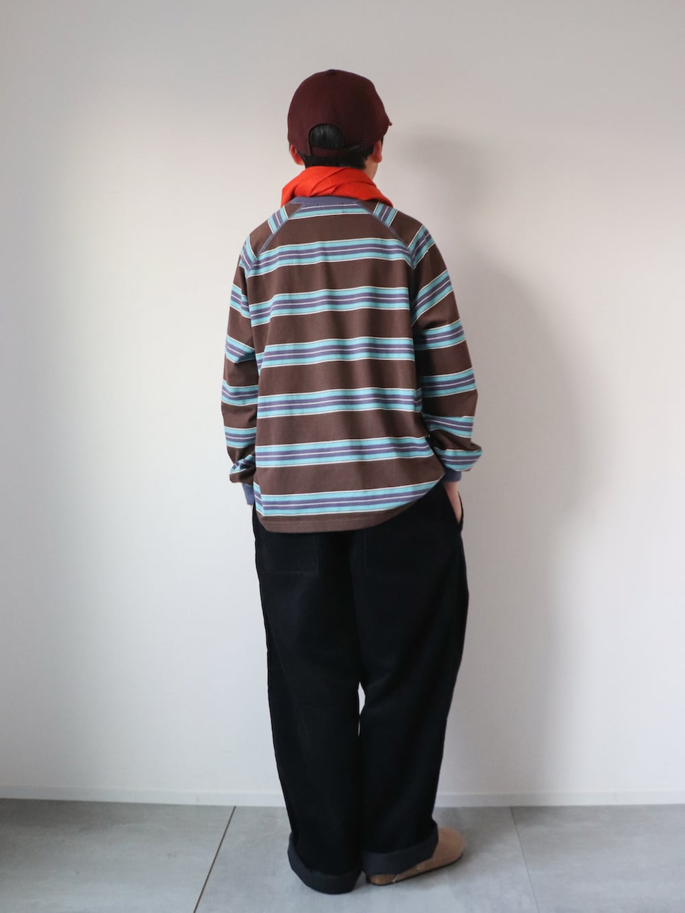 ブラウン系のTシャツ/カットソー、ブラック系のパンツ、ベージュ系のスリッポンを着用したキッズの冬コーディネートの2枚目の写真