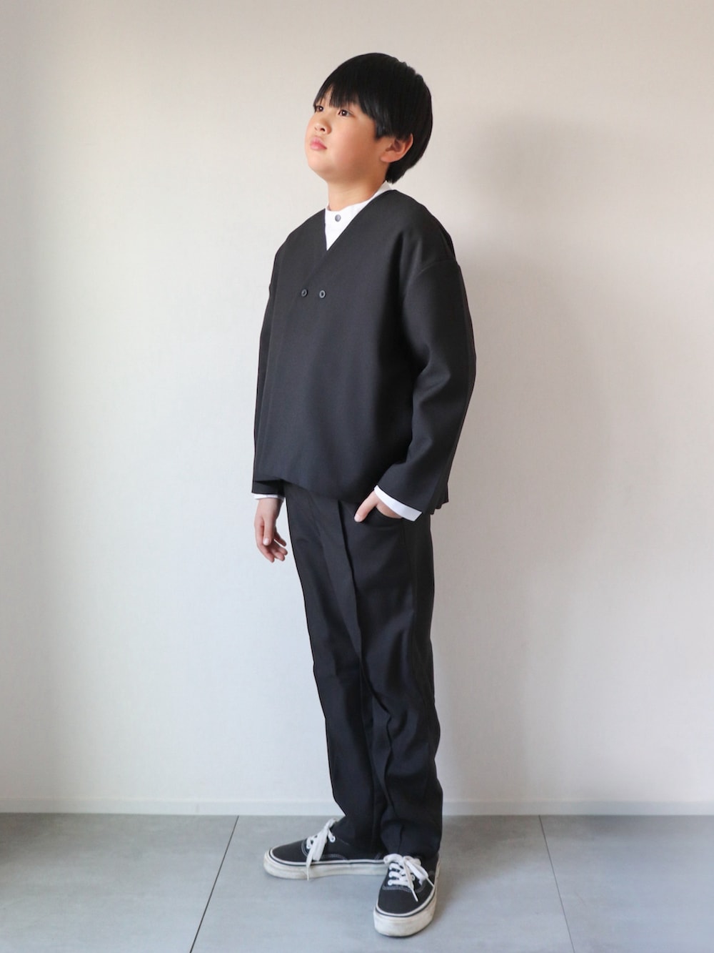 ブラック系のスーツセット、ホワイト系のシャツ/ブラウス、ブラック系のスニーカーを着用したキッズの冬コーディネートの2枚目の写真
