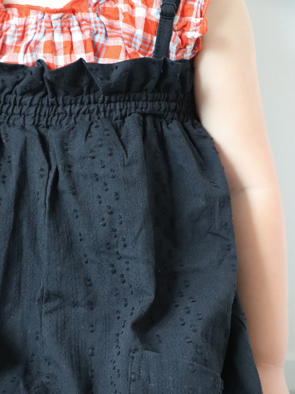 ブラック系のサロペット/オーバーオール、レッド系のチュニック、その他のサンダルを着用したキッズの夏コーディネートの2枚目の写真