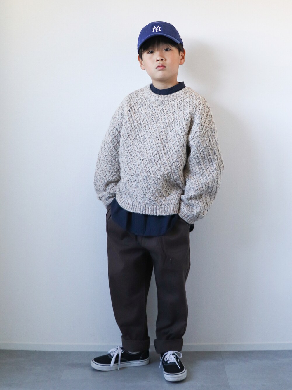 ブラック系のモッズコート、ホワイト系のニット/セーター、ブルー系のシャツ/ブラウスを着用したキッズの冬コーディネートの3枚目の写真