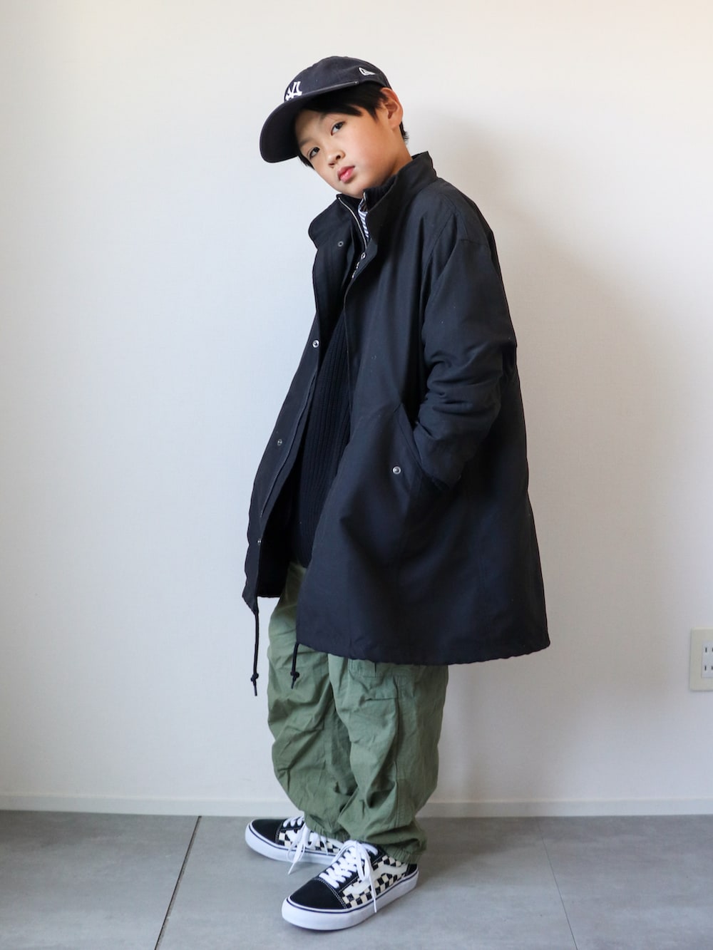 ブラック系のモッズコート、ブラック系のニット/セーター、ブラック系のシャツ/ブラウスを着用したキッズの冬コーディネートの3枚目の写真