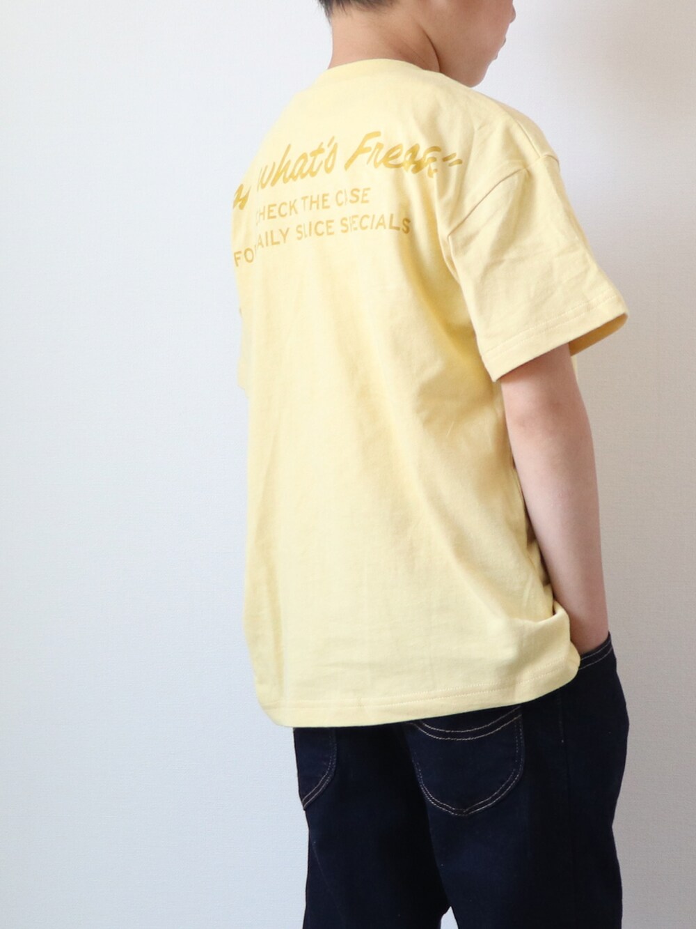 イエロー系のTシャツ/カットソー、ブルー系のデニムパンツ、ブラック系のサンダルを着用したキッズの夏コーディネートの3枚目の写真