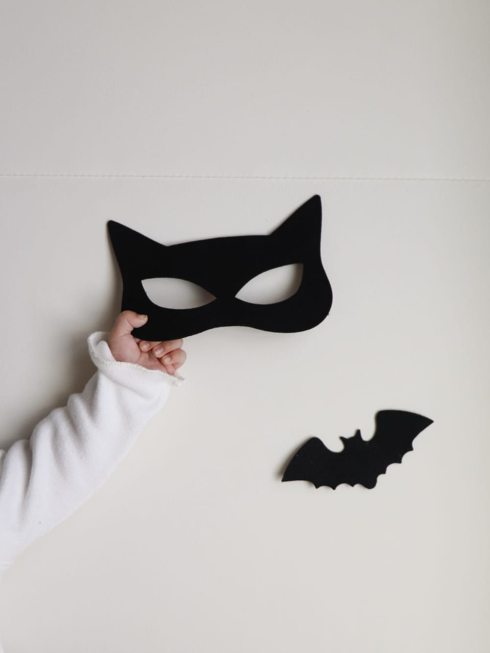 ブラック系の帽子、ベージュ系のロンパース、ブラック系のロンパースを着用したキッズの秋コーディネートの4枚目の写真