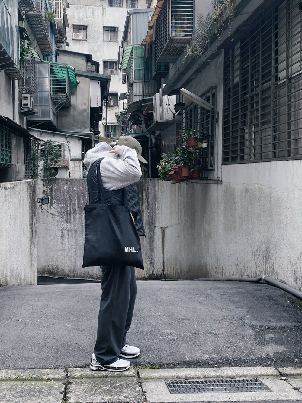 グレー系のパーカー、グレー系のその他パンツ、ブラック系のトートバッグを着用したメンズの冬コーディネートの3枚目の写真