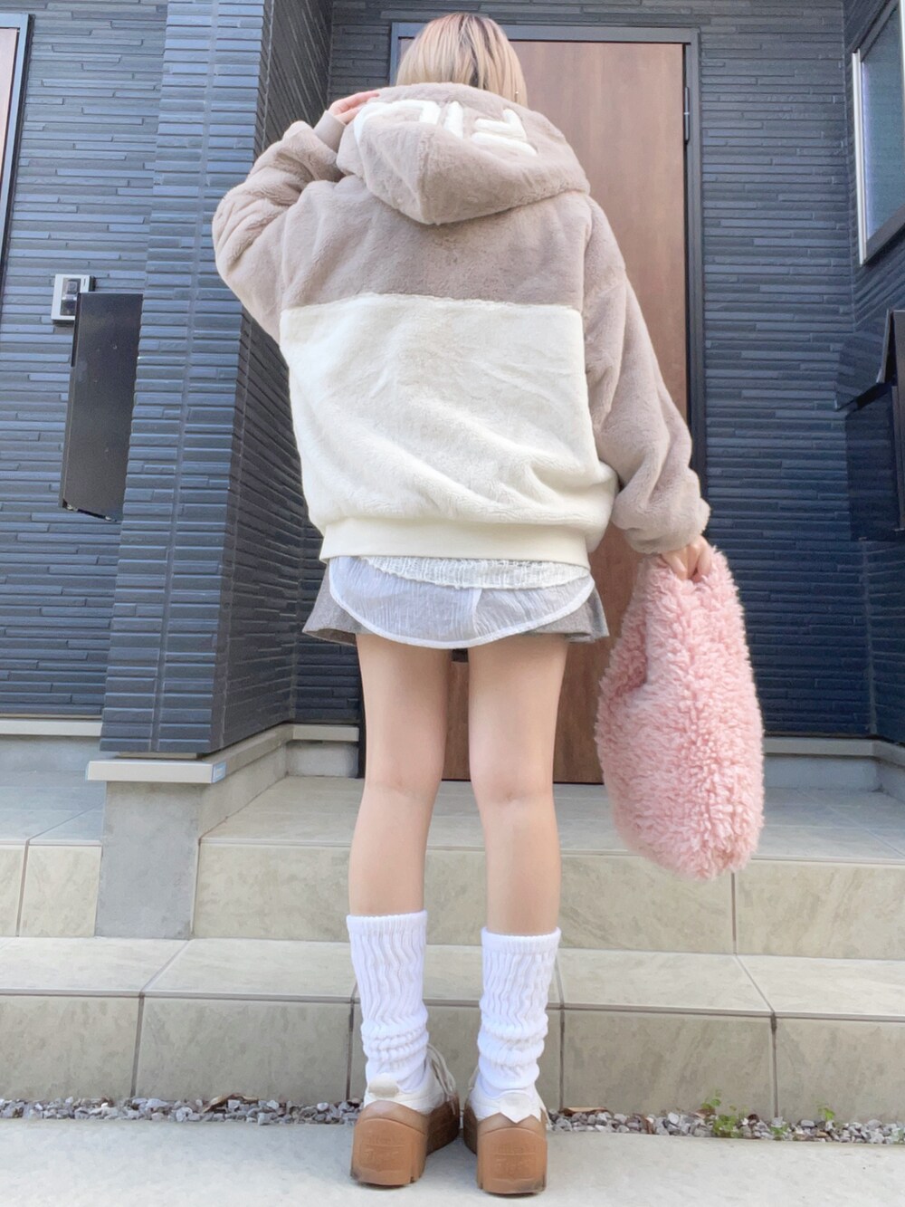 ホワイト系のスニーカー、ブラウン系のスカート、ベージュ系のその他アウターを着用したレディースの秋コーディネートの2枚目の写真