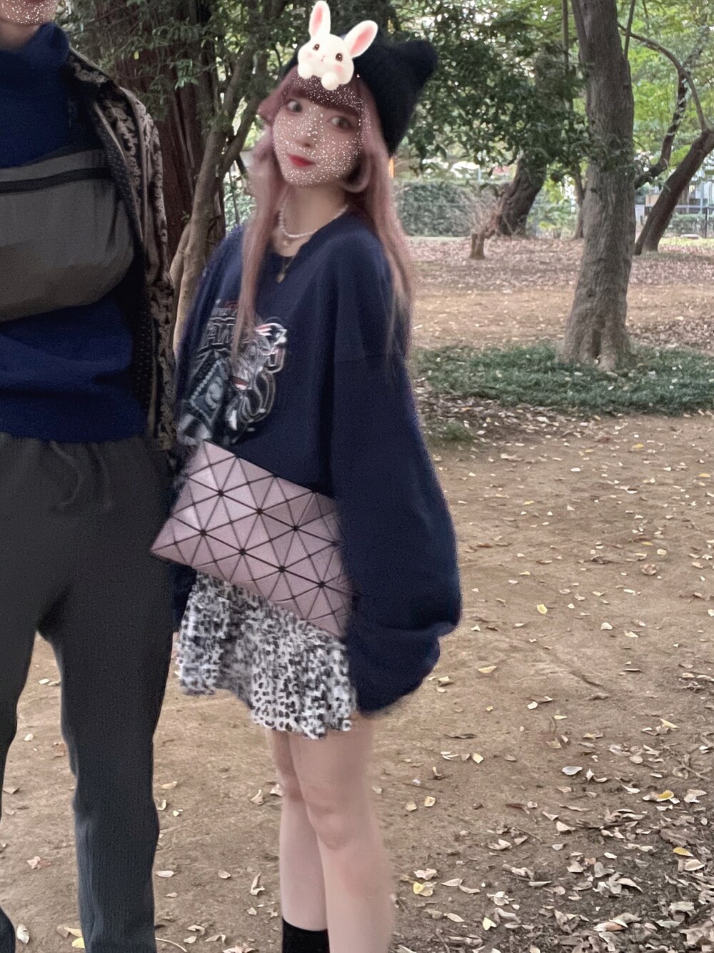 パープル系のバッグ、ホワイト系のスウェット、ブラック系のサンダルを着用したレディースの秋コーディネートの2枚目の写真