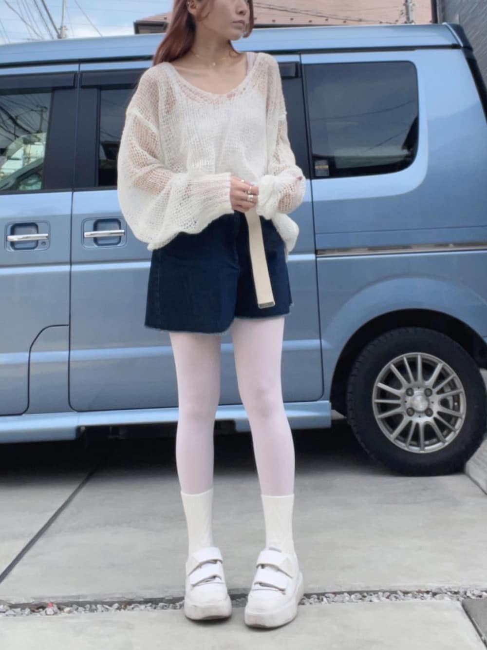 ホワイト系のスニーカー、ブルー系のデニムスカート、ホワイト系のニット/セーターを着用したレディースの冬コーディネートの3枚目の写真