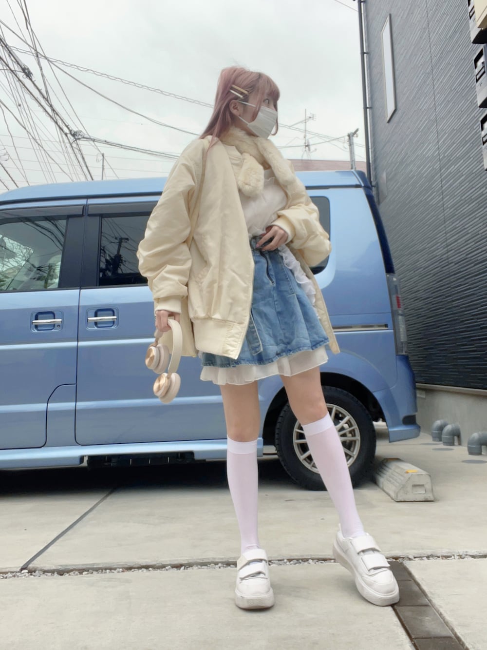 ホワイト系のスニーカー、ブルー系のデニムスカート、ホワイト系のMA-1を着用したレディースの冬コーディネートの2枚目の写真