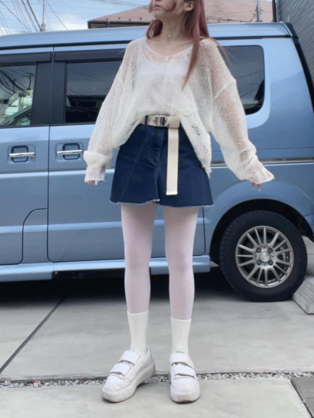 ホワイト系のスニーカー、ブルー系のデニムスカート、ホワイト系のニット/セーターを着用したレディースの冬コーディネートの2枚目の写真