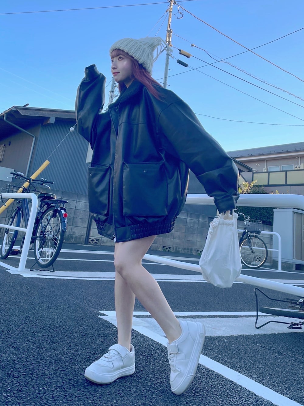 ホワイト系のスニーカー、ブラック系のスウェット、ブラック系のその他パンツを着用したレディースの冬コーディネートの2枚目の写真