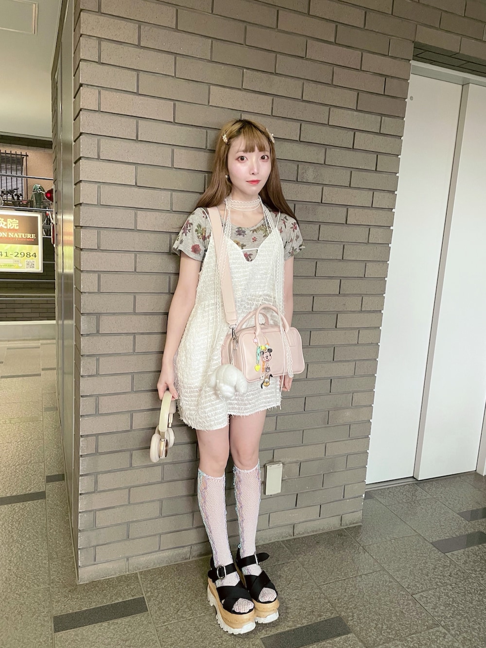 ブラック系のサンダル、ピンク系のショルダーバッグ、ホワイト系のワンピースを着用したレディースの夏コーディネートの2枚目の写真