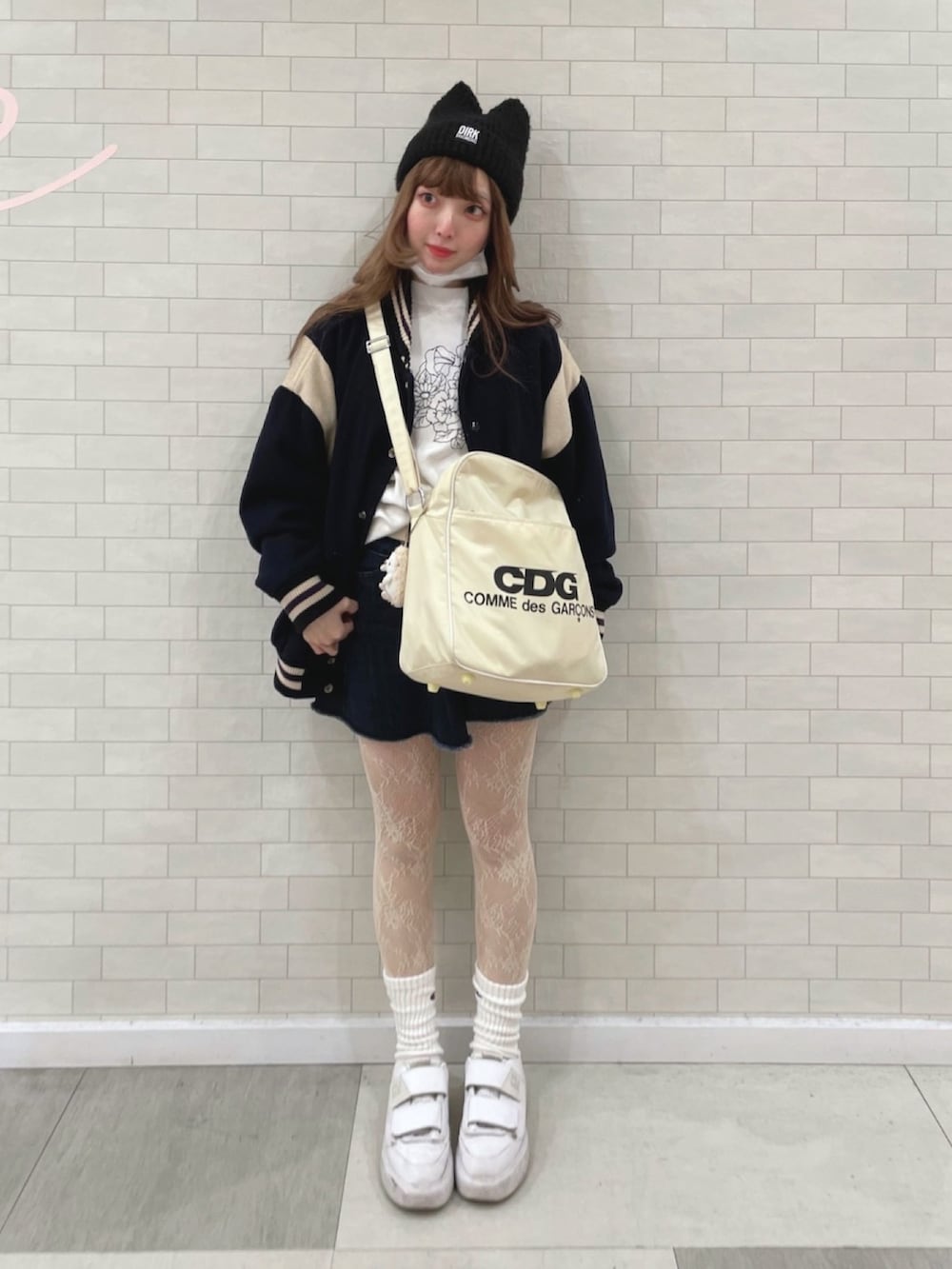 ホワイト系のショルダーバッグ、ブルー系のデニムスカート、ブルー系のスタジャンを着用したレディースの秋コーディネートの2枚目の写真