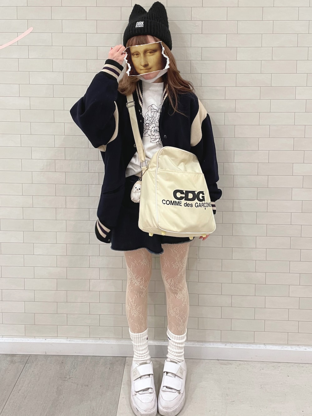 ホワイト系のショルダーバッグ、ブルー系のデニムスカート、ブルー系のスタジャンを着用したレディースの秋コーディネートの3枚目の写真