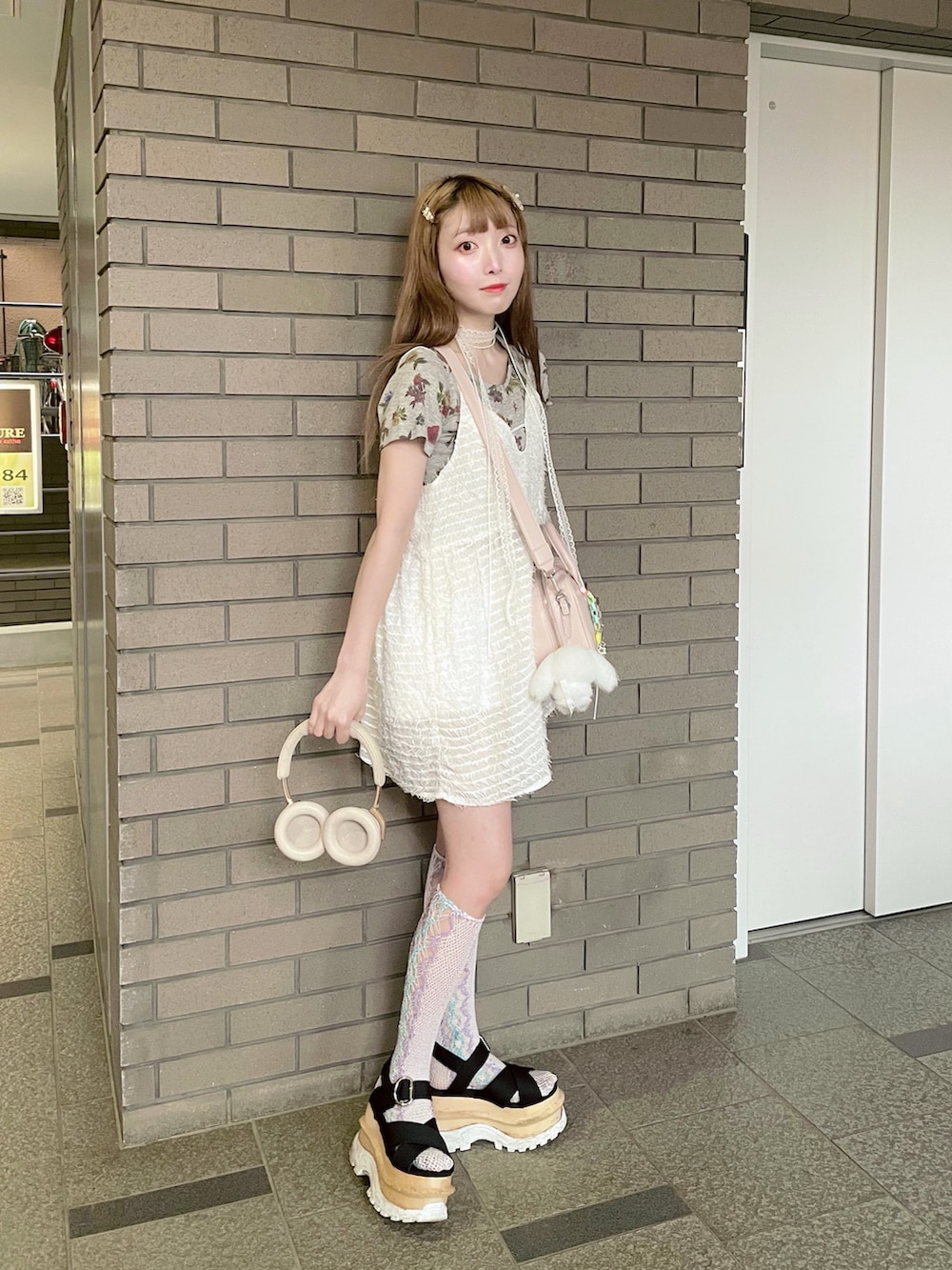 ブラック系のサンダル、ピンク系のショルダーバッグ、ホワイト系のワンピースを着用したレディースの夏コーディネートの3枚目の写真