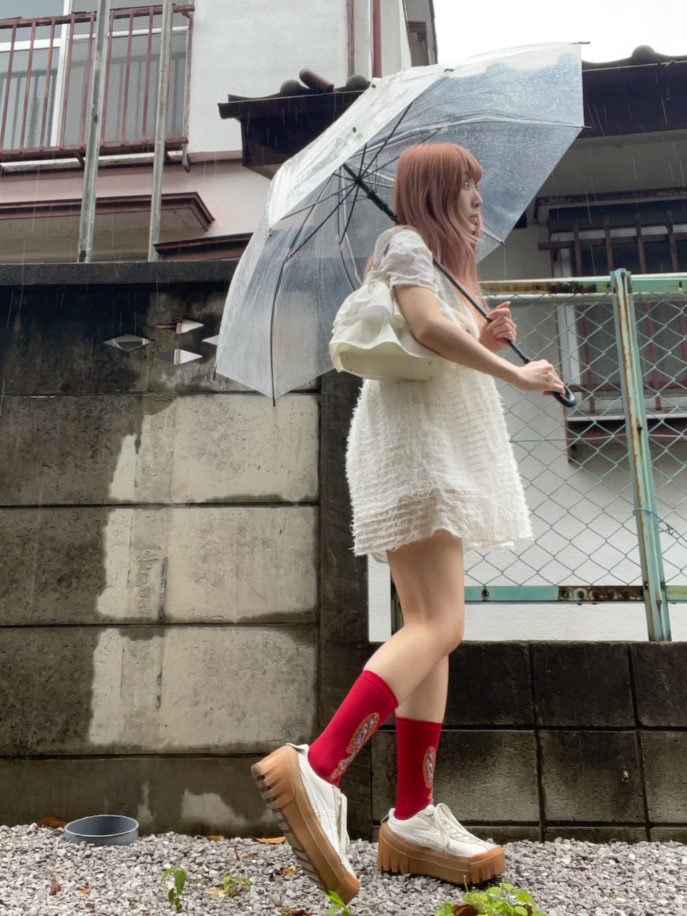 ホワイト系のスニーカー、ホワイト系のハンドバッグ、ホワイト系のワンピースを着用したレディースの夏コーディネートの2枚目の写真