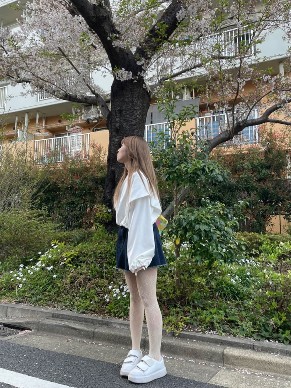 ホワイト系のスウェット、ブルー系のデニムスカート、ホワイト系のスニーカーを着用したレディースの春コーディネートの3枚目の写真